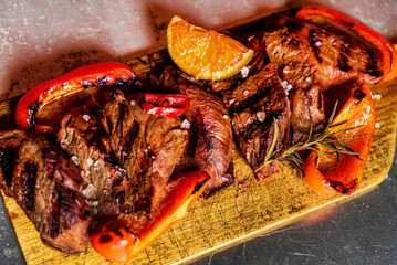 grilled pork with vegetables on wooden board
