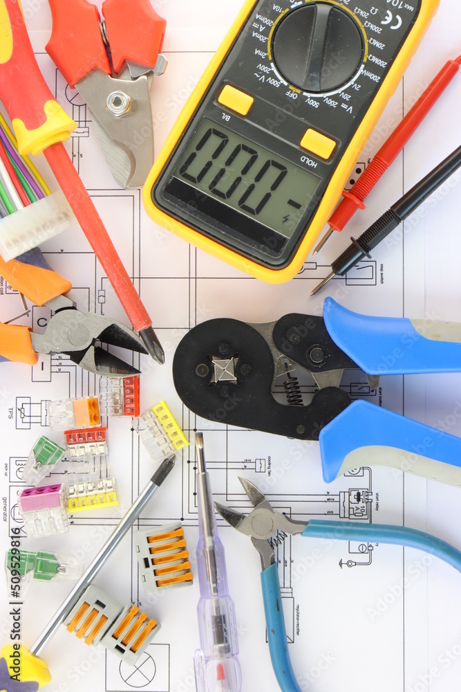 Wall mural Multimeter and tools for installing an electrical control panel in close-up on an electrical diagram.