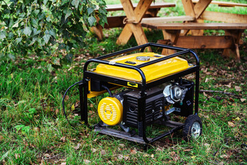 Portable power generator. Compact equipment for powering various devices in nature and in places without power supply. Selective focus. Foreground - obrazy, fototapety, plakaty
