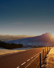 road lit by rising sun in the mountains