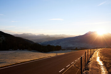 road lit by rising sun in the mountains