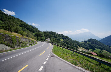 Naklejka premium Asphalt road in Alp mountains. Road trip concept. Beautiful landscape.