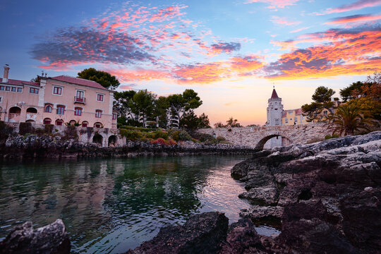 Museu Condes de Castro Guimar&atilde;es, Beautiful palace and ancient stone bridge against sunset sky. Cascais, Portugal.