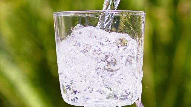 Pure Water Poured Into Glass Closeup. Slow motion. Clear fresh drinking water filling glass. Quenching thirst concept. High quality 4k footage
