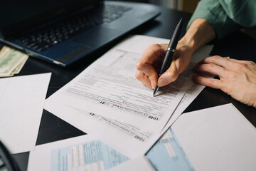 Woman filling US tax form 1040. tax form us business income office hand fill concept. Closeup