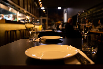 Empty white plate in restaurant setting