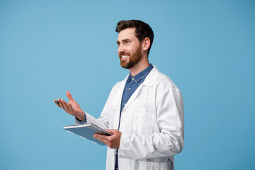 Naklejka na ściany i meble Doctor consults patient holding tablet in hands standing over blue studio background