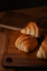 Tasty fresh croissant on wooden cutting board ready to serve. Levitation, bread bakery products cafe concept