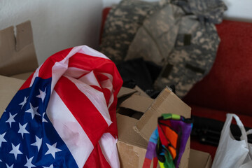 Naklejka premium boxes with things to move, military uniform and flag of America