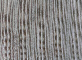 Beige fabric texture. Original textile background. Linen blanket on a bed with a linear ornament.