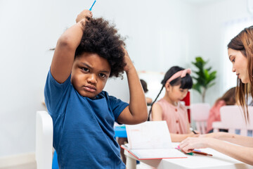 Portrait of Stressed African black child boy learning in class room. 