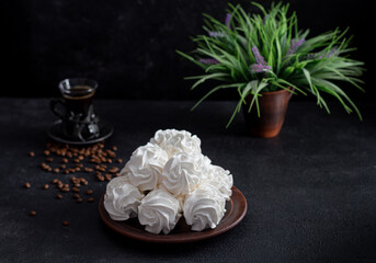 apple zepfyr on a dark background in a plate in the background - a cup of coffee. Coffee drinking concept.