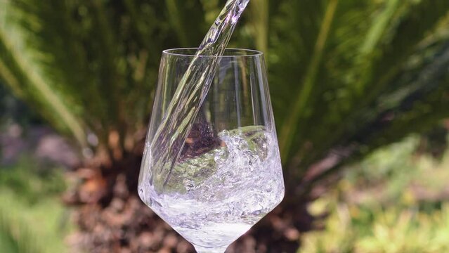 Pure Water Poured Into Glass Closeup. Slow motion. Clear fresh drinking water filling glass. Quenching thirst concept. High quality 4k footage