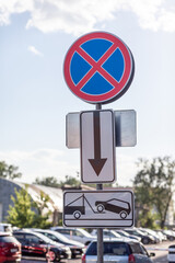 The road sign prohibits stopping against the background of buildings and cars. Close-up road signs...