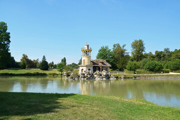 Fototapeta na wymiar Title: The Marlborough Tower and pond in the Queen s Hamlet at Marie-Antoinette s Estate near Versailles Palace.