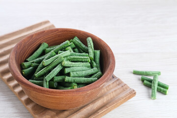 Yard long bean or Kacang Panjang served in wooden bowl, food preparation.
