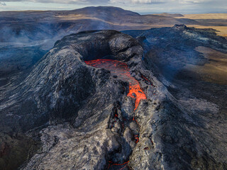 View into the crater of an active volcano with lava flow at the beginning of an eruption. Landscape...