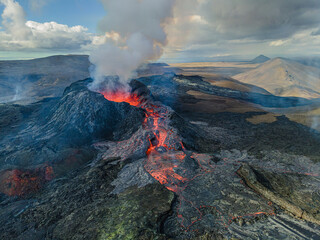 Magma flow of lava flows from the volcanic crater. View into the volcanic crater from above during...