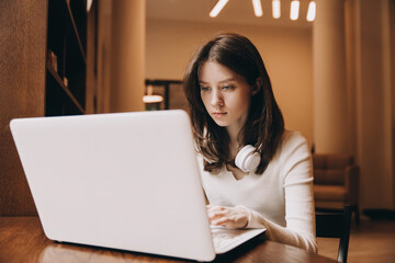 Young beautiful student girl working, learning in college library