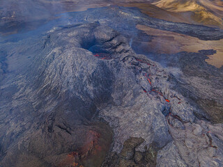 active volcano on Reykjanes peninsula by day. Volcanic crater in Iceland. Dark magma rock around...