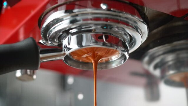 Espresso Extracted through Bottomless Portafilter in Red Coffee Maker in Slow Motion