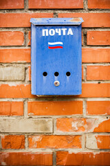 blue mailbox on a brick wall, russian post, russia flag