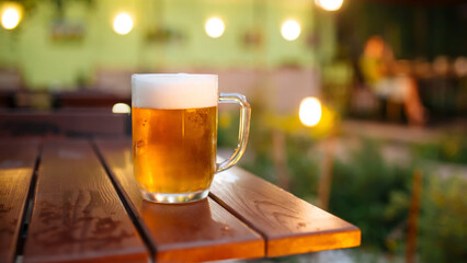 Mug of fresh light beer on the outdoor terrace table