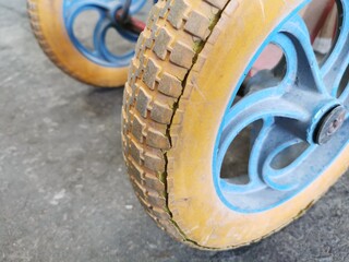 Close up image wheelbarrow tyre with cracked sidewall and worn rubber tread. Selective focus.