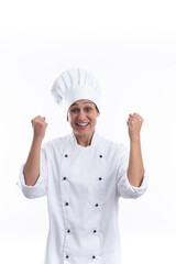 Young hispanic girl chef successful on white background very happy and excited gesturing winner with raised arms, smiling and shouting for success. Vertical format with copy space.