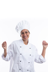 Young hispanic girl chef on white background dancing very happy and excited with raised arms, smiling for success. Vertical format with copy space.