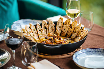 Pan of seafood stew with toasted bread and wine on served table