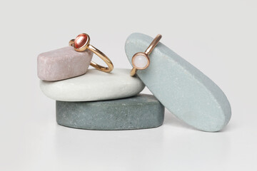 Jewelry fashion photography. Costume jewelry rings displayed on decorative oval stones, studio product shot.