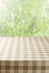 An empty table with a napkin. Blurry summer or spring background