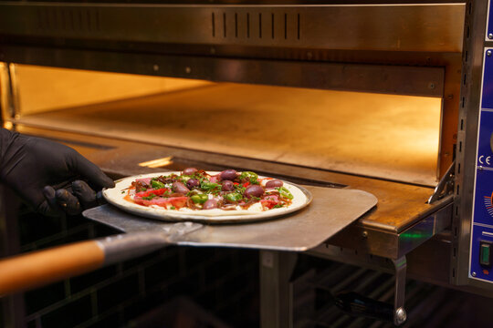 Pizza wird in den Ofen geschoben