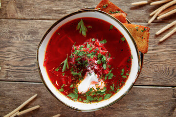 Bowl of russian beet soup borscht on wooden background