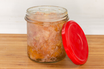 Braised pork in open small jar with removed screwed lid