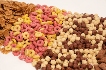 A set of different quick breakfast cereals - rings and balls, top view on white.
