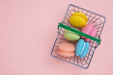 Fototapeten French macarons cookies in shopping basket on pink background. © freeman83