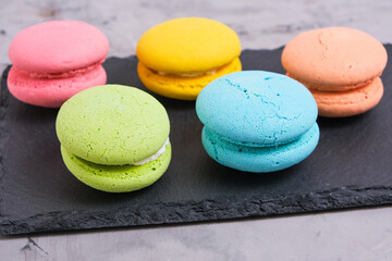 Colorful and bright macarons cookies gray background.