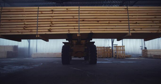 The loader is carrying the floorboards. Warehouse of a woodworking plant. Board floor loading in the warehouse of finished products. High quality 4k footage
