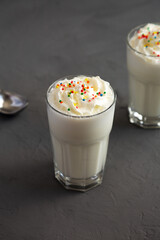 Homemade Vanilla Milk Shake with Whipped Cream, side view.