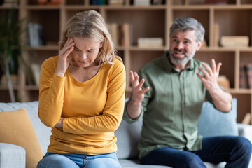 Psychological Abuse. Angry Middle Aged Husband Screaming At Upset Wife At Home