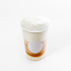 Plastic cup with hot cappuccino coffee with foam on a white background, close-up. Mock up