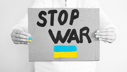 Russia's war against Ukraine. Woman with a message to stop the war. "STOP WAR" text plate.