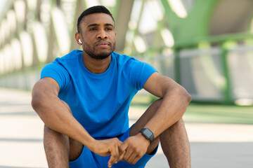Fototapeta premium Fitness and healthy lifestyle concept. Athletic young guy sitting on the floor after training