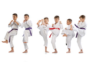 Sport training of 6 little kids, beginner karate fighters in white doboks practicing together...