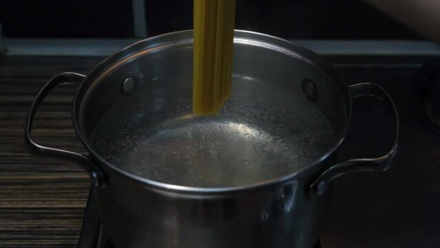 Throwing spaghetti pasta into water