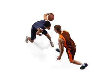 Top view portrait of two men, professional basketball players in motion, training isolated over...