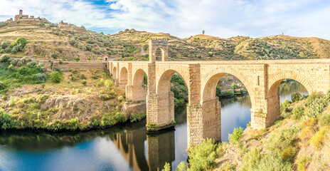 Panoramic view at the ancient Roman bridge over Tajo river in Alcantara, Spain - obrazy, fototapety, plakaty