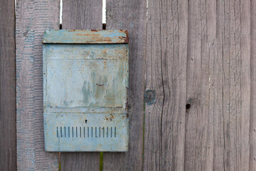 an old rusty mailbox is hanging on a wooden fence. banner with space for text
